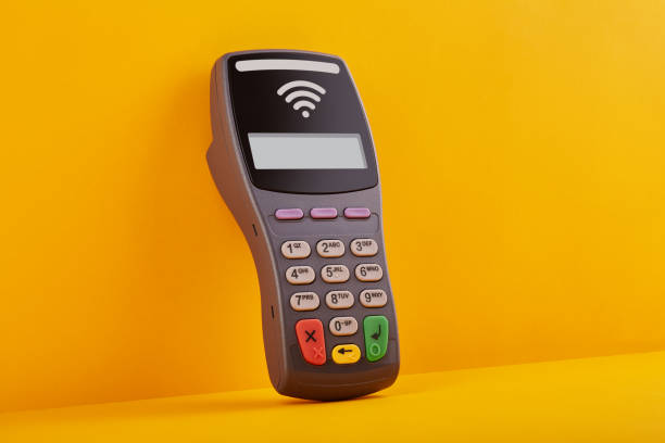 istock Wireless, contactless credit card reader leaning against the yellow wall 1213166604