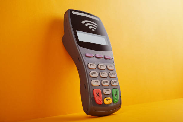 istock Wireless, contactless credit card reader leaning against the yellow wall 1213166782