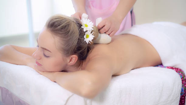 istock Massage therapist using herbal compress with woman 1213170156
