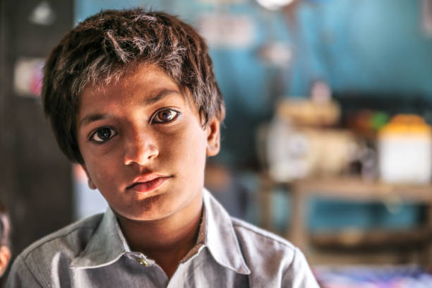 closeup of a poor staring hungry orphan boy in a refugee camp with sad expression on his face and his eyes are full of pain closeup of a poor staring hungry orphan boy in a refugee camp with sad expression on his face and his eyes are full of pain orphan stock pictures, royalty-free photos & images