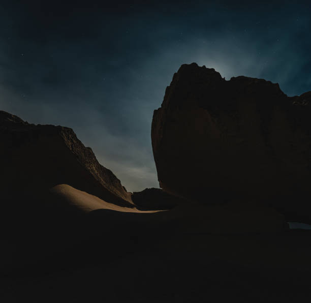 istock Nighttime long exposure of dramatic coastal rock formation backlit by moonlight 1213180969