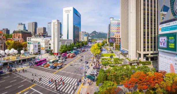 High angle panoramic view over the busy pedestrian crossings and highway traffic along Sejongno-daero from City Hall to Gyeongbokgung in the heart of downtown Seoul, South Korea’s vibrant capital city.