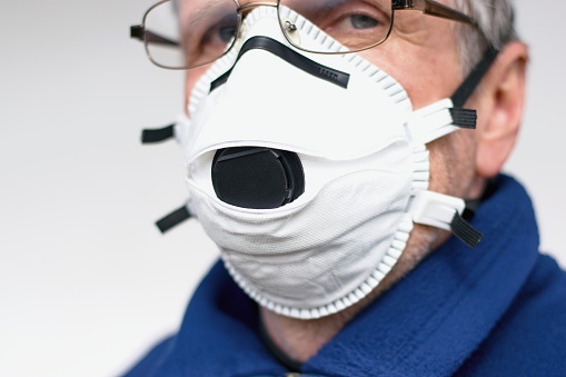 Senior man protected with FFP3 respirator. Coronavirus protection concept