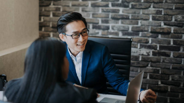 2 asian chinese white collar workers having discussion  using laptop 2 asian chinese white collar workers having discussion  using laptop asian property stock pictures, royalty-free photos & images