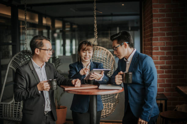 istock a group of asian chinese white collar workers having discussion during their coffee break in lounge using laptop and digital tablet 1213186746
