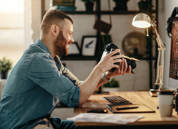 Cheerful man checking pictures on camera at home