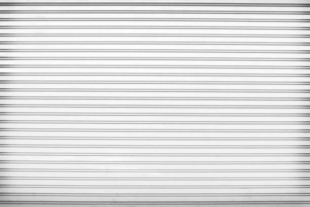 istock Rolling steel door texture or roller shutter door line patterns  , white grey background 1213190646