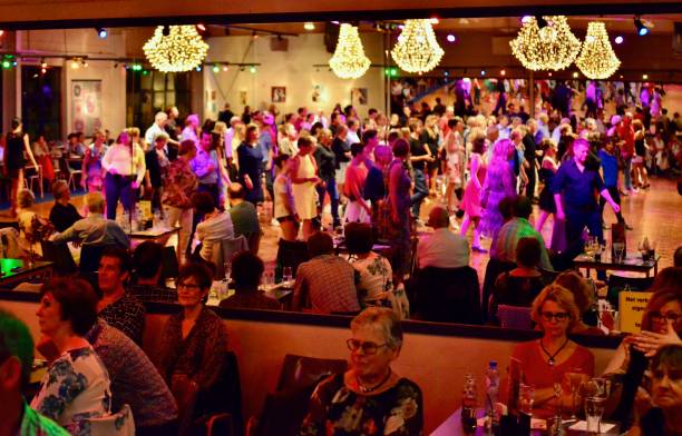 Workshop classes. Indoor line dancing by a professional instructor. Herent, Belgium - September 14, 2019: Open House indoor dancing classes evening show. Photo reportage open door promotion indoor dance classes. Courses starting half September. Teacher in front of group demonstrates solo dance. People sitting on table. Reflection mirroring. teacher retirement party stock pictures, royalty-free photos & images