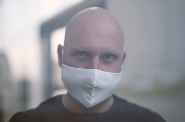 istock Infected man in isolation, looking out the window. Soft focus 1213194053