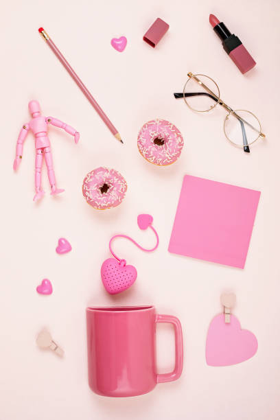 istock Flat lay with pink accessories, tea cup, donuts, glasses, lipstick over  light pink background 1213194656