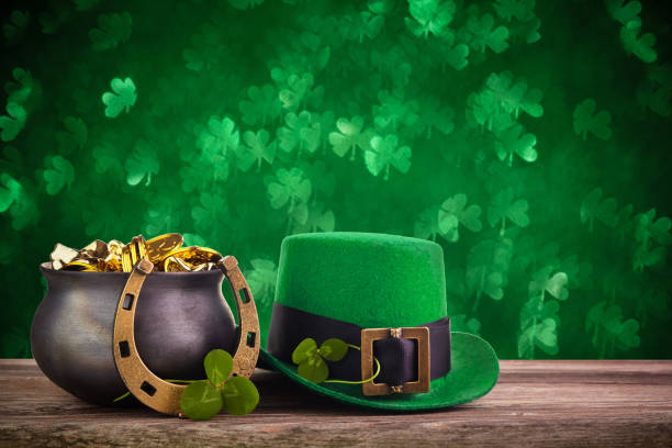 st patrick's day kapelusz i garnek ze złotymi monetami na zielonym migotanie bokeh tle - leprechaun holiday zdjęcia i obrazy z banku zdjęć