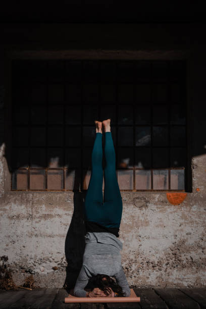 Young yoga attractive woman practicing yoga concept, headstand pose, workout