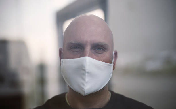istock Infected man in isolation, looking out the window. Soft focus 1213197503