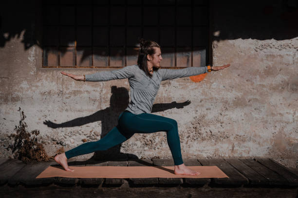 Young yoga attractive woman practicing yoga concept, standing in Warrior one exercise pose, working out