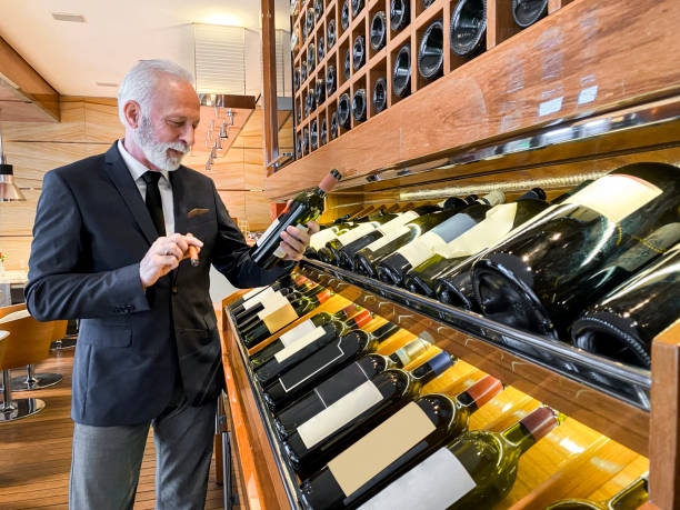 istock A senior wine steward looking at a wine selection on a display rack in an exclusive bar 1213199882