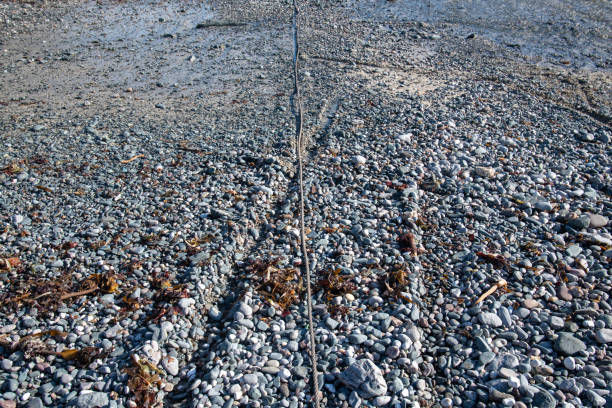 Fishing boat winch line laying on stones
