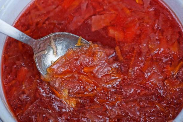istock metal spoon picks up red borsch in a white pan 1213201991