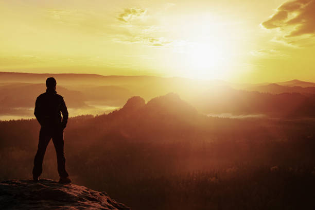 A traveler man standing on the mountain top at sunrise. High quality photo