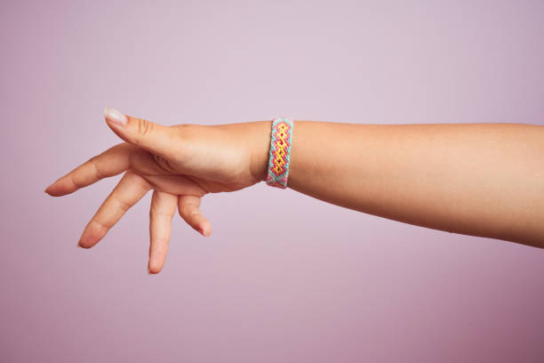 Arm of model woman with beautiful handmade colorful bracelet on wrist Model arm with beautiful handmade colorful bracelet on wrist friendship bracelets hands stock pictures, royalty-free photos & images