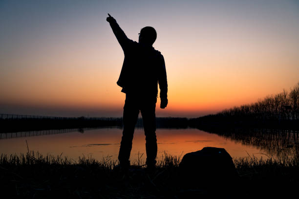 Hikers standing by the lake at sunset