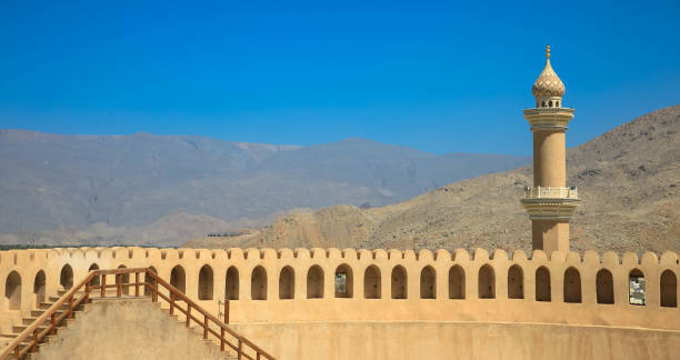 istock Minaret behind a fortified wall under a clear blue sky. 1213205552
