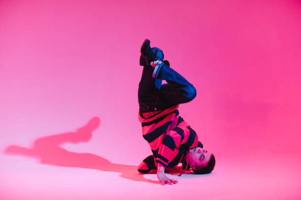 istock Young Man in a Jumper Dancing Contemporary Dance in Studio. Breakdancing. Dance School Poster. Copy Space. Battle competition announcement. Pink and Blue Background. 1213205694