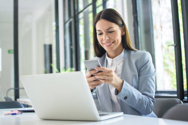 istock Beautiful young business woman using phone in office 1213209145