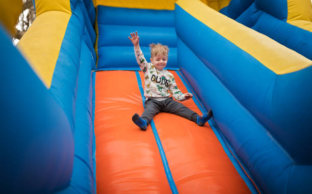 istock Little boy sliding down on a bouncy castle 1213209823