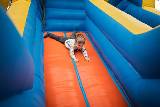istock Little boy sliding down on a bouncy castle 1213209867