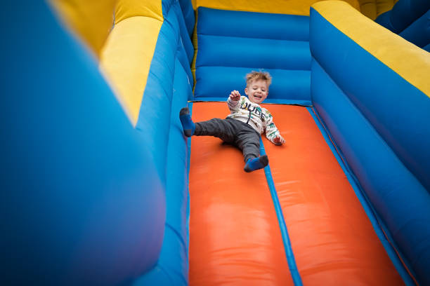 istock Cute boy sliding down on a bouncy castle 1213210090