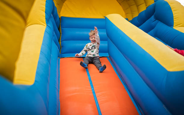 istock Boy sliding down on a bouncy castle 1213210174