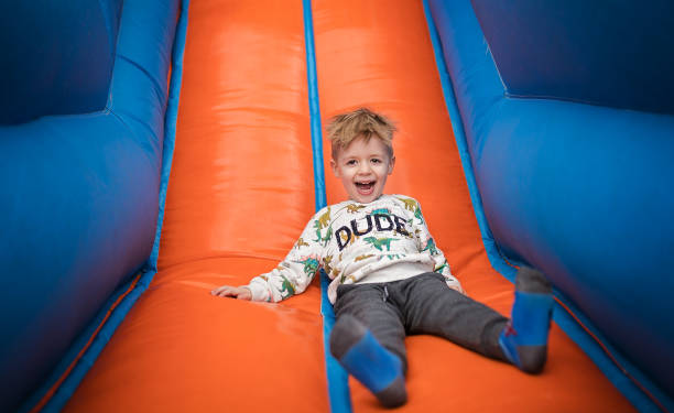 istock Boy sliding down on a bouncy castle 1213210213