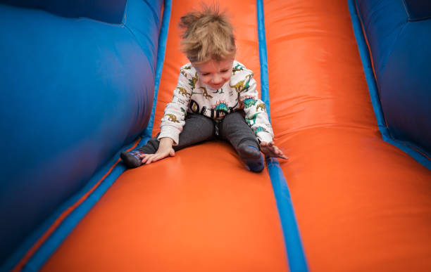 istock Boy sliding down on a bouncy castle 1213210241