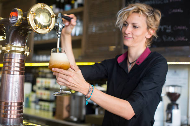 istock Bartender woman with blond hair serving beer. 1213211433