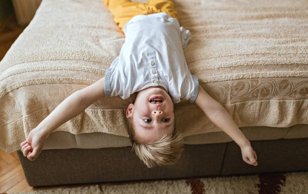 istock Little boy lying in bed upside down 1213211487