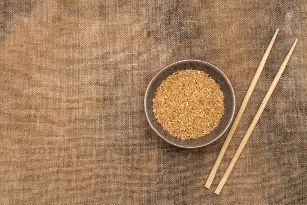 A bowl of rice and wooden chopsticks on sacking. Copy-paste. Space for text