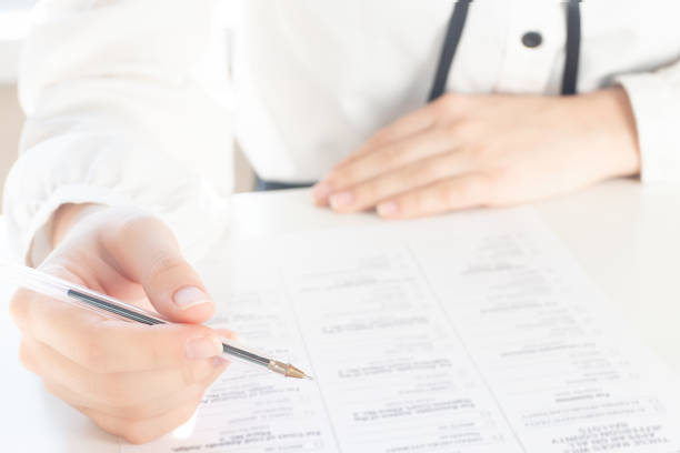 istock Filling out documents for obtaining a visa of a foreign state. Hands hold a pen over paper 1213218127