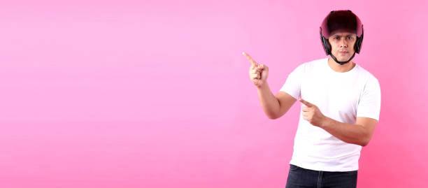 istock Asian man wearing a helmet motor and Pointing finger on empty space.on pink background in studio With copy space. 1213220771