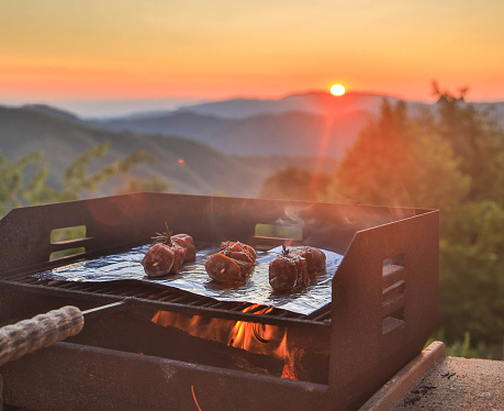 Barbecue with fire in nature, sunset in the mountains, Tuscany Italy