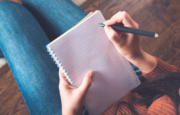 istock woman hand pen with notepad 1213223457