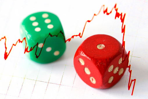 A red and green dice and a negative market trend against a white background