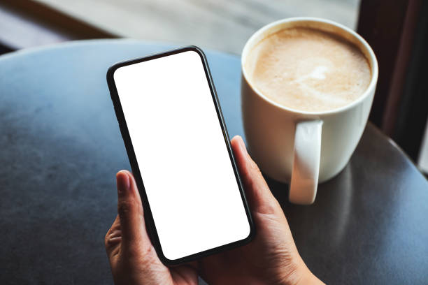 istock a woman holding mobile phone with blank white screen with coffee cup on the table 1213224842