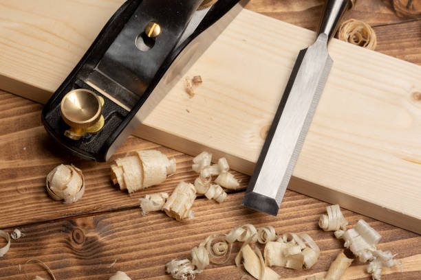 istock Chisel and small block plane with wood shavings 1213229873