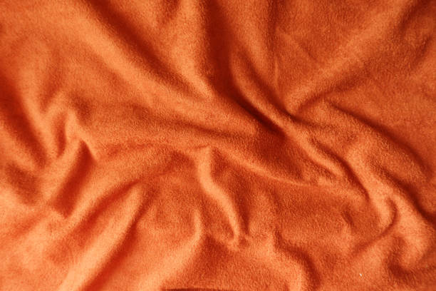 istock Crumpled bright reddish orange artificial suede fabric 1213230193