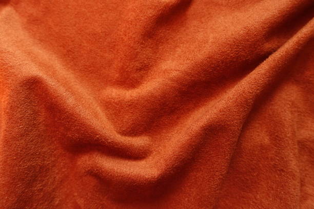 istock Soft folds on bright reddish orange artificial suede fabric 1213230716
