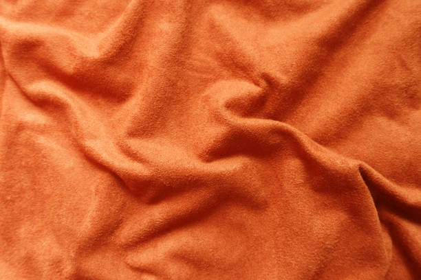 istock Texture of bright reddish orange artificial suede fabric in soft folds 1213230762