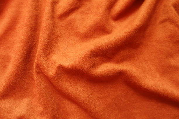 istock Surface of bright reddish orange artificial suede fabric in soft folds 1213230827