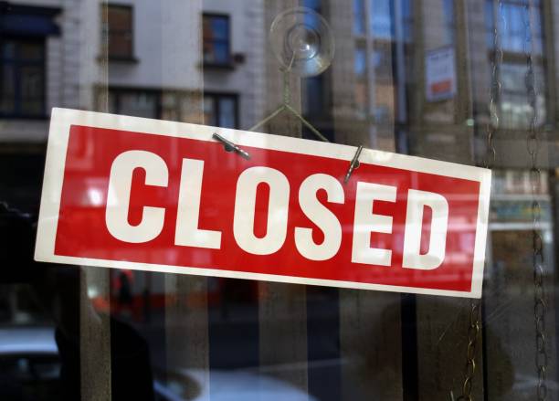 Closed sign in shop window Closed sign a in shop window with blurred background reflections shut up stock pictures, royalty-free photos & images