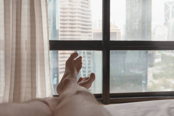 istock Bare feet of a man lying in a bed 1213234775