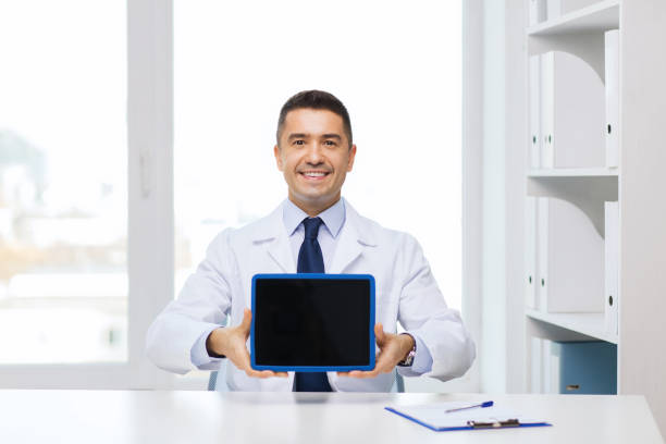 istock smiling male doctor showing tablet pc blank screen 1213234847